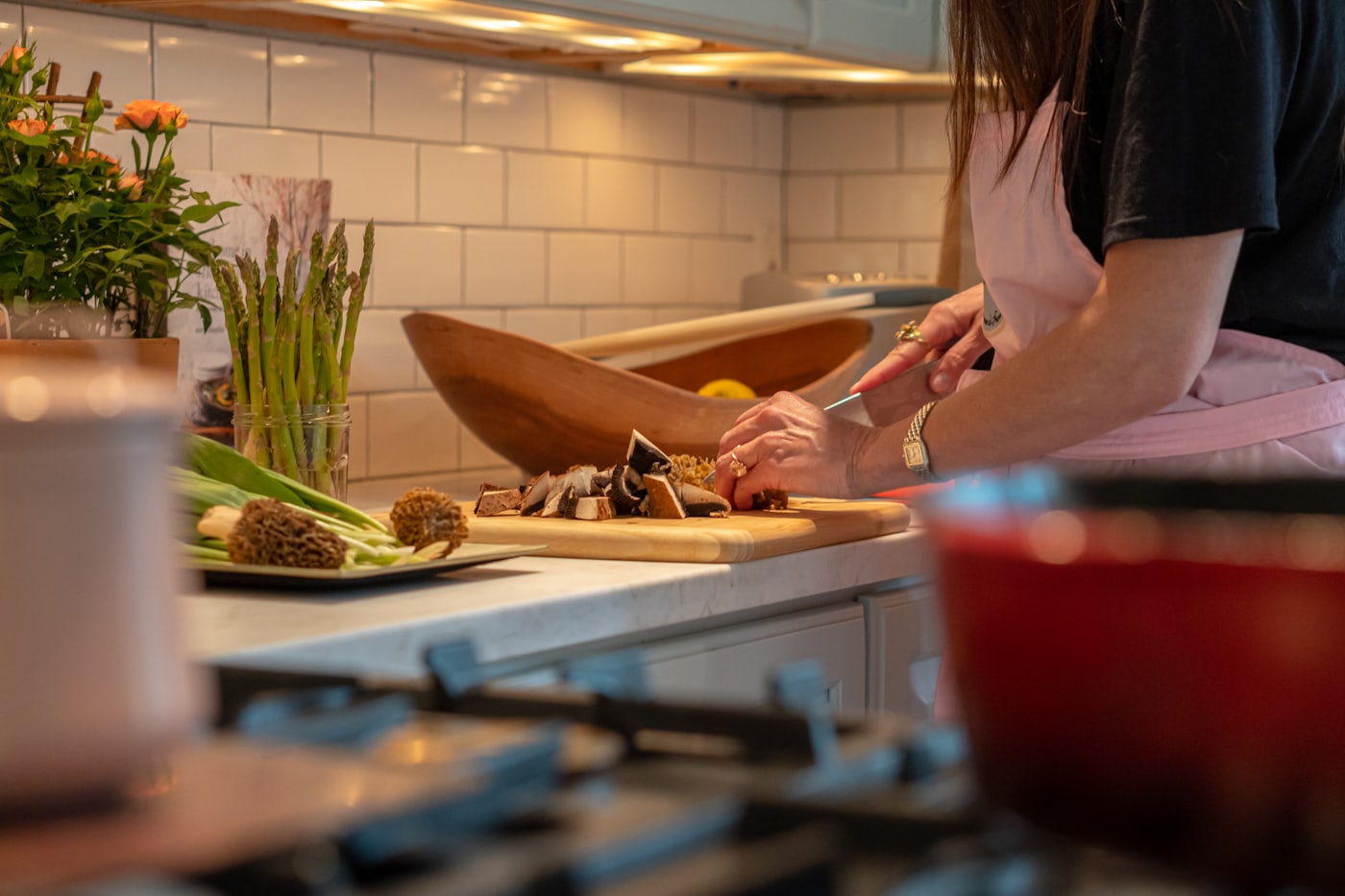Manos preparando comida en una cocina con luz cálida